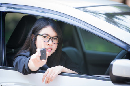 Asian businesswoman is stressed and looks at the broken car's room, calling a repairman.
