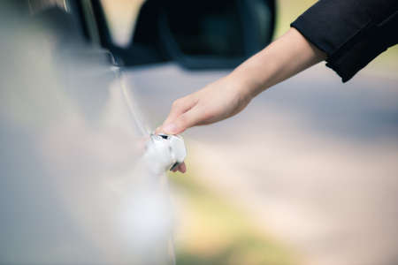 Hand of a businesswoman with a key opening the car doorの写真素材