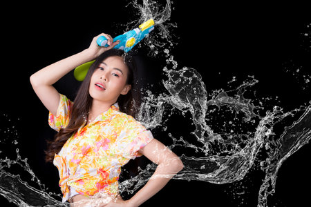 Young happy beauty Asian woman holding plastic water gun at Songkran festival, Thailand. Thai New...