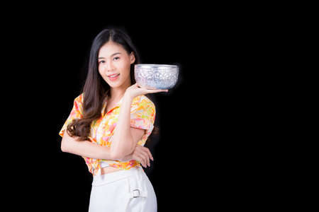 Thai girl smiling Asian beauty Swimming with ancient bowls Preserve the good culture of Thai people during Songkran festival. Thai New Year, Family Day in Aprilの写真素材