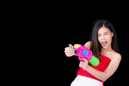 Young happy beauty Asian woman holding plastic water gun at Songkran festival, Thailand. Thai New Year's Day. Isolated on black background, Family Day in Aprilの写真素材