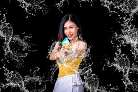 Portrait cheerful young asian woman Wearing a yellow tank top ,holding plastic water gun Smiling and...