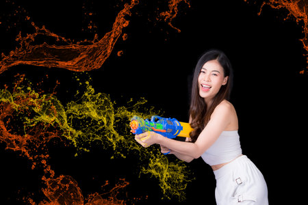 Portrait cheerful young asian woman Wearing a yellow tank top ,holding plastic water gun Smiling and...