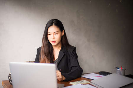 Office time, Asian young woman working in office With stress and business communication through mobile phones, executives, business womenの写真素材