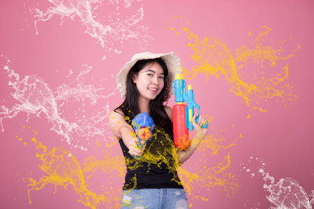 Portrait cheerful young asian woman holding plastic water gun Smiling and having fun playing in the...