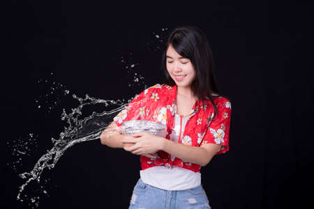 Thai girl smiling Asian beauty Swimming with ancient bowls Preserve the good culture of Thai people during Songkran festival. Thai New Year, Family Day in Aprilの写真素材