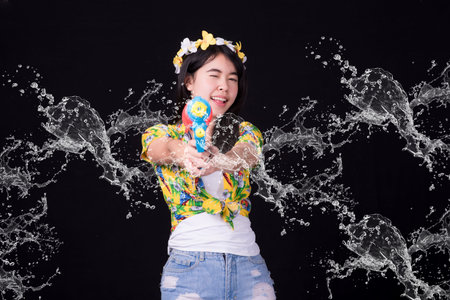 Portrait cheerful young asian woman holding plastic water gun Smiling and having fun playing in the...