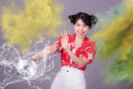 Thai girl smiling Asian beauty Swimming with ancient bowls Preserve the good culture of Thai people during Songkran festival. Thai New Year, Family Day in Aprilの写真素材
