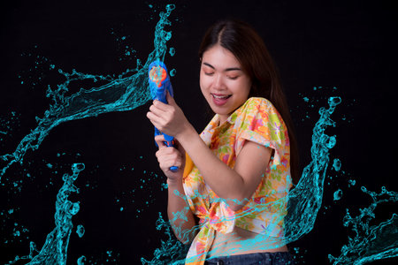Portrait cheerful young asian woman holding plastic water gun Smiling and having fun playing in the...