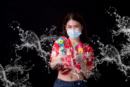 Portrait cheerful young asian woman holding plastic water gun Smiling and having fun playing in the...