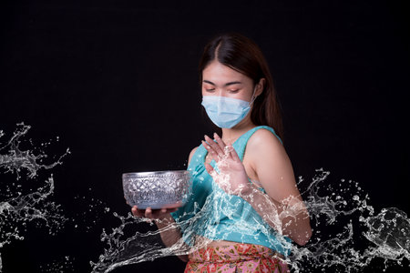 Thai girl smiling Asian beauty Swimming with ancient bowls Preserve the good culture of Thai people during Songkran festival. Thai New Year, Family Day in Aprilの写真素材