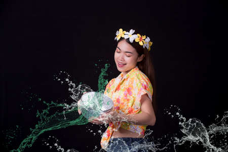 Thai girl smiling Asian beauty Swimming with ancient bowls Preserve the good culture of Thai people during Songkran festival. Thai New Year, Family Day in Aprilの写真素材