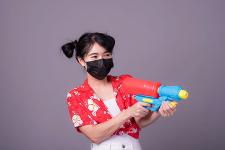 Portrait cheerful young asian woman holding plastic water gun Smiling and having fun playing in the...
