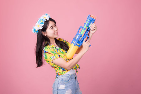Portrait cheerful young asian woman holding plastic water gun Smiling and having fun playing in the...