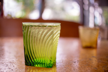 Green Glass with water on a wooden table.の写真素材