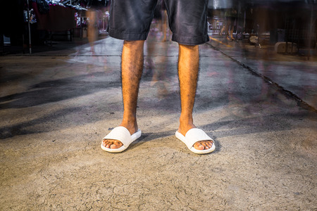 Standing amidst the people .One of the men in pants and casual shoes Among people at night.の写真素材