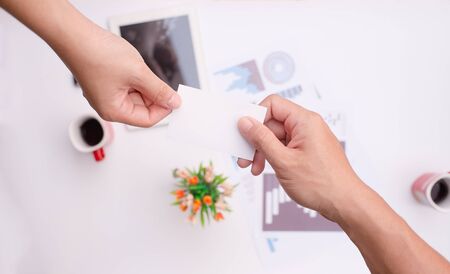 Hands business card exchange .He sent a white business card or white label On the desk in office.の写真素材