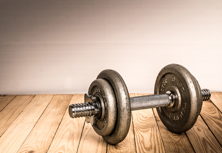 Dumbbells , weight plates on wooden background for bodybuilder. Concept for sport player or workout. gym of accessories for fitnessの写真素材