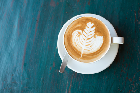 Cup of Hot Cappuccino coffee with fresh milk Art's surface floating on top . on rustic wooden background and copy Spaceの写真素材