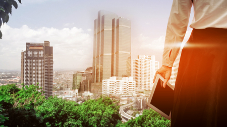 Attractive Modern business woman holding Digital tablet Screen in  building City Scape . Analyst Department Researching Process . Young Girl Working New Startup .の写真素材