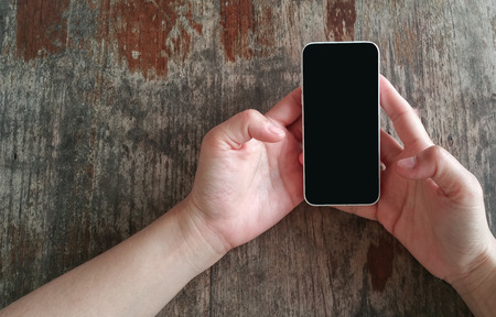Hands using smart phone on table .の写真素材