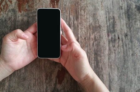 Hands using smart phone on table .の写真素材