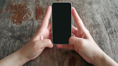 Hands using smart phone on table .の写真素材
