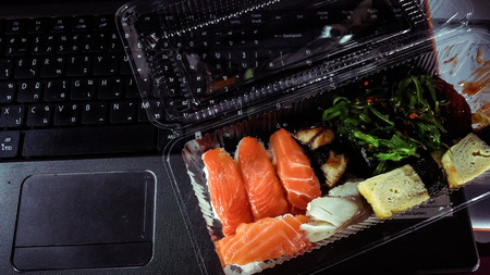 Appetizer Sushi On a computer notebook for eat at the office now that are working. Works very well, no time to eat sushi restaurant .sushi at working overtime Concept.の写真素材