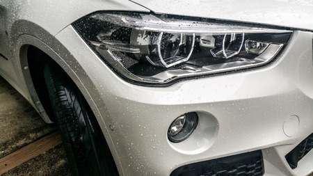 Modern car headlights Front of White car On the day of wet wipers. Garage Themeの写真素材