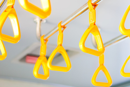 handle on the MRT, prevent toppling.underground railway system or metro,people holding onto a handle on a train and the bus,selective focusの写真素材