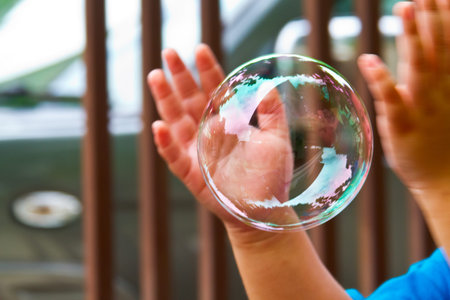 Soap bubbles are floating through in hand of the little children.
