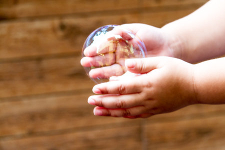 soap bubbles are floating through in hand of the little children.