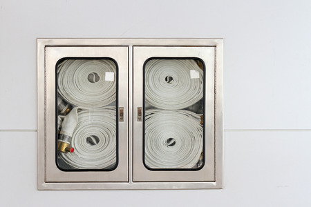 Fire hose in a box on the wall ready for fire.の写真素材