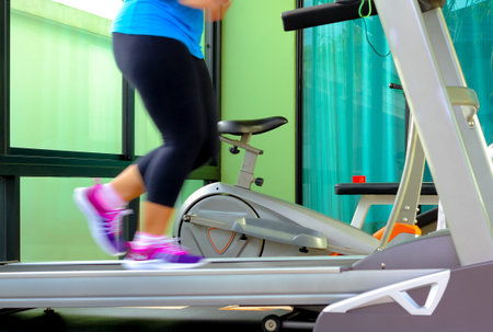 Jogging to lose weight to be healthy,legs wearing sneakers running on treadmill.
