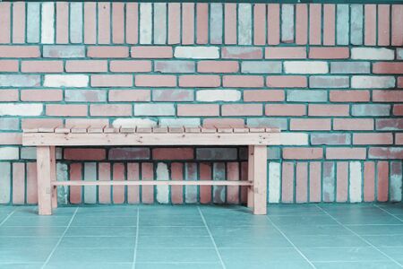 wooden chair on tile floor with brick wall backgroundの写真素材