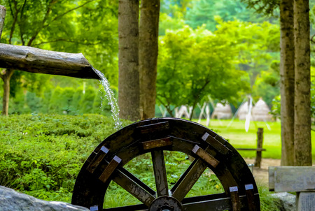 water flows from a wooden pipe or water gushing out of the pipe close upの写真素材