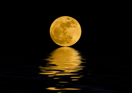 Full moon over night waterの写真素材