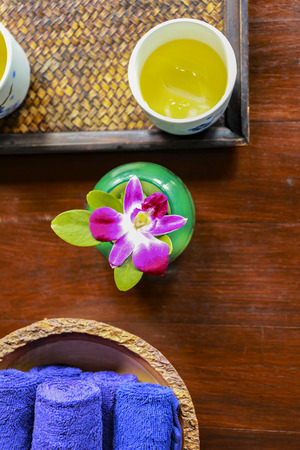 Spa concept : Handkerchief and cool drinking water on wooden backgroundの写真素材
