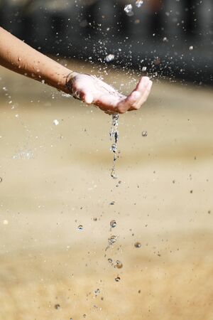 Water Pouring in Child's Handsの写真素材