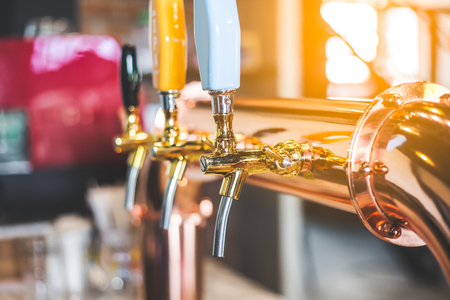 golden shiny beer taps in beer barの写真素材