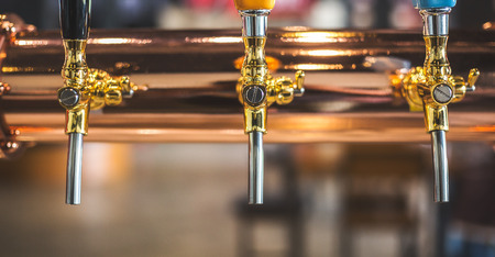 golden shiny beer taps in beer barの写真素材
