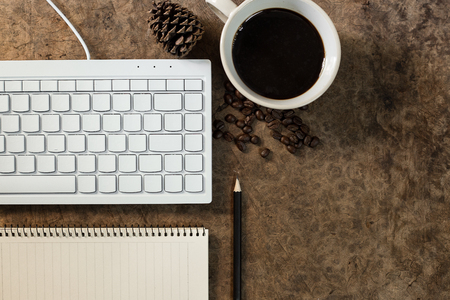 Work with the keyboard and have a coffee mug on the wooden floor.の写真素材