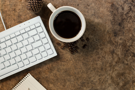 Work with the keyboard and have a coffee mug on the wooden floor.の写真素材