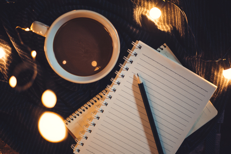 Pencil and coffee are placed on the notebook.の写真素材