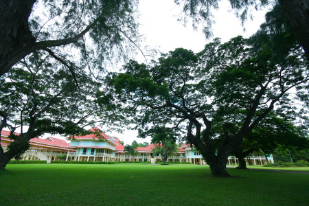 PHETCHABURI, THAILAND -JULY 27 2009:  Green field and  Mrigadayavan Palace, Summer palace of the king. Made from wood in thai mix Europe style. Location near beach of thai bay.のeditorial素材