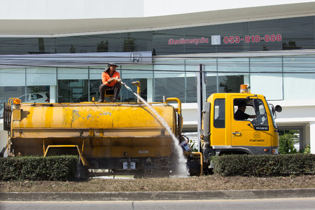CHIANG MAI, THAILAND -JANUARY 24 2017: Man Watering a tree in Center of Road on tank truck of Department of Highways. Photo at road no 1001.のeditorial素材