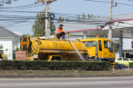 CHIANG MAI, THAILAND -JANUARY 24 2017: Man Watering a tree in Center of Road on tank truck of Department of Highways. Photo at road no 1001.のeditorial素材