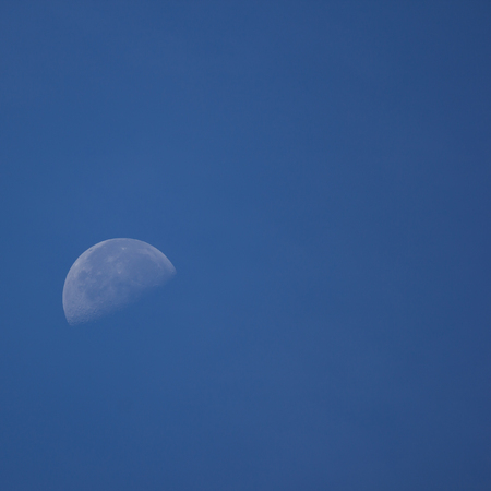 Close up of The Moon in the Morning time with blue sky backgroundの写真素材