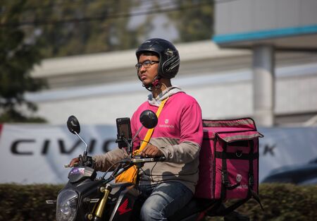 Chiangmai, Thailand - January 9 2020: Delivery service man ride a Motercycle of Food Panda. On road no.1001, 8 km from Chiangmai city.のeditorial素材