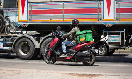 Chiangmai, Thailand -  May 1 2020:  Delivery service man ride a Motercycle of Grab Food. On road no.1001, 8 km from Chiangmai city.のeditorial素材